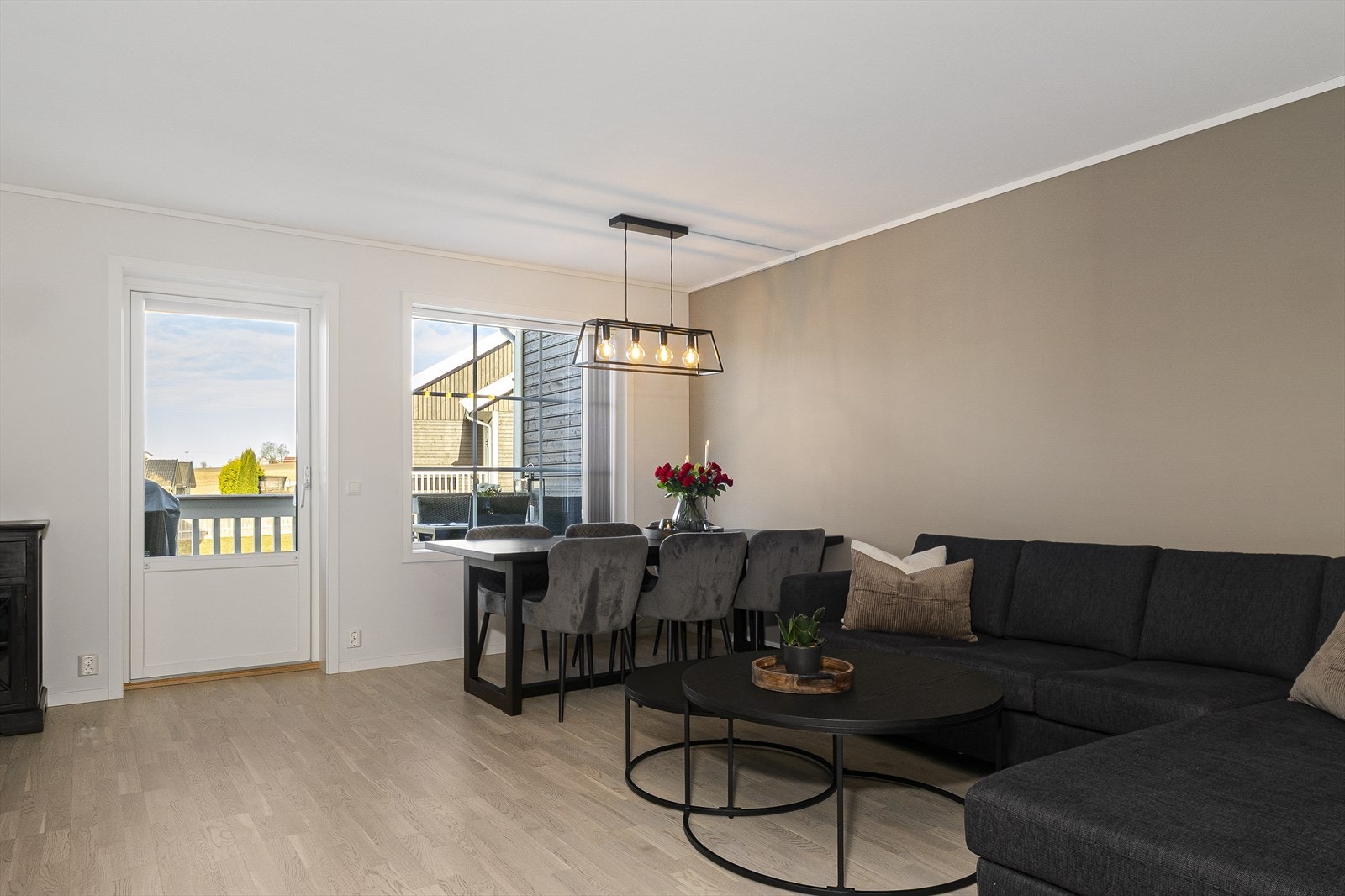 Romslig stue med naturlige soner for sofa og spisegruppe. Galleribilde