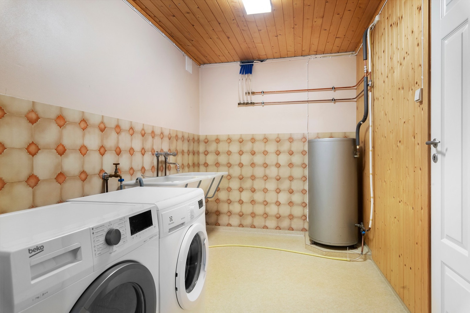 Romslig vaskerom med standard fra byggeår, veggventil mot yttervegg, dobbelt skyllekar og god plass til både vaskemaskin og tørketrommel. VV tank på 150 l Galleribilde