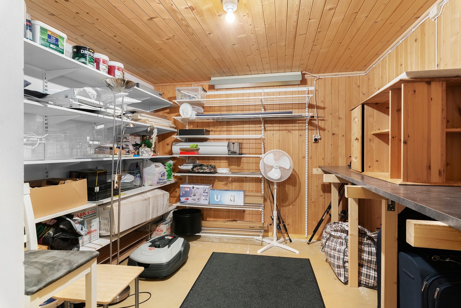 Stor lagringsbod i underetasjen med panel på veggflater Galleribilde