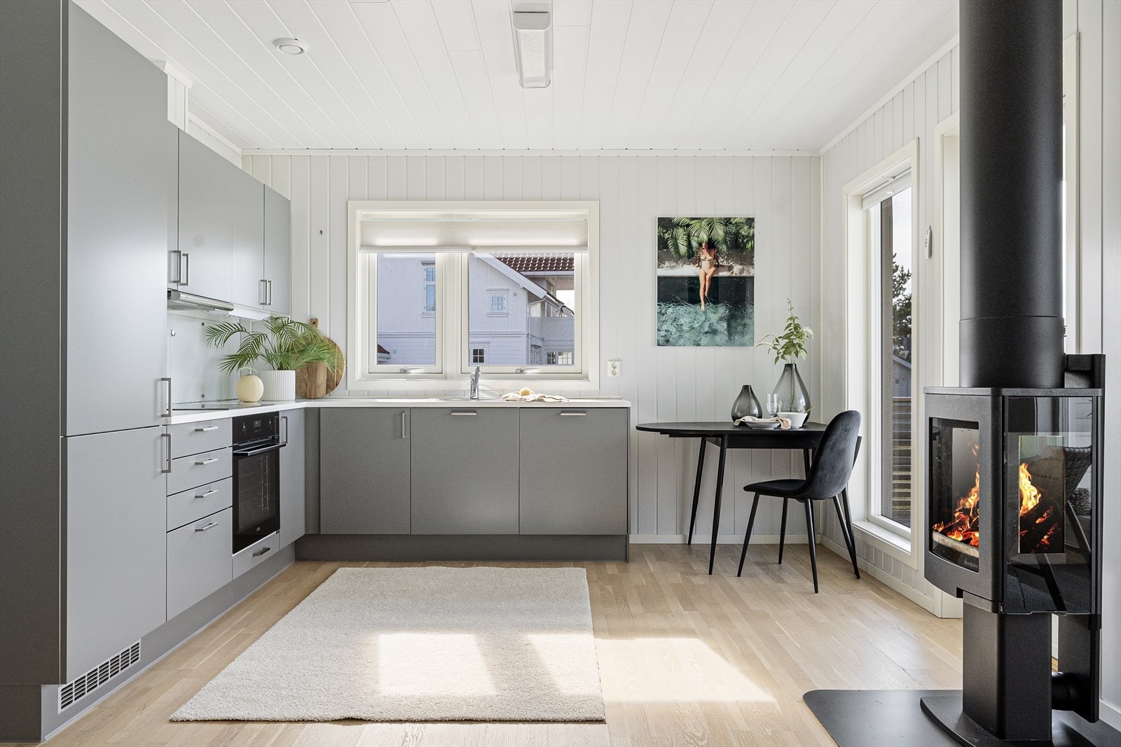 Smakfullt kjøkken med plass til et lite spisebord. Galleribilde