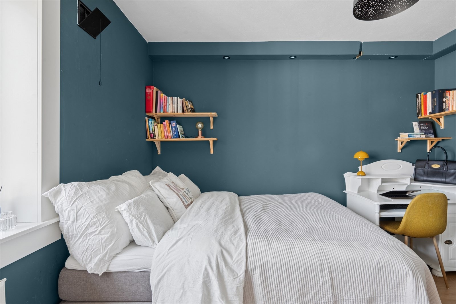 Over sengen henger to enkle, men sjarmerende bokhyller med god plass til favorittbøkene dine. Galleribilde