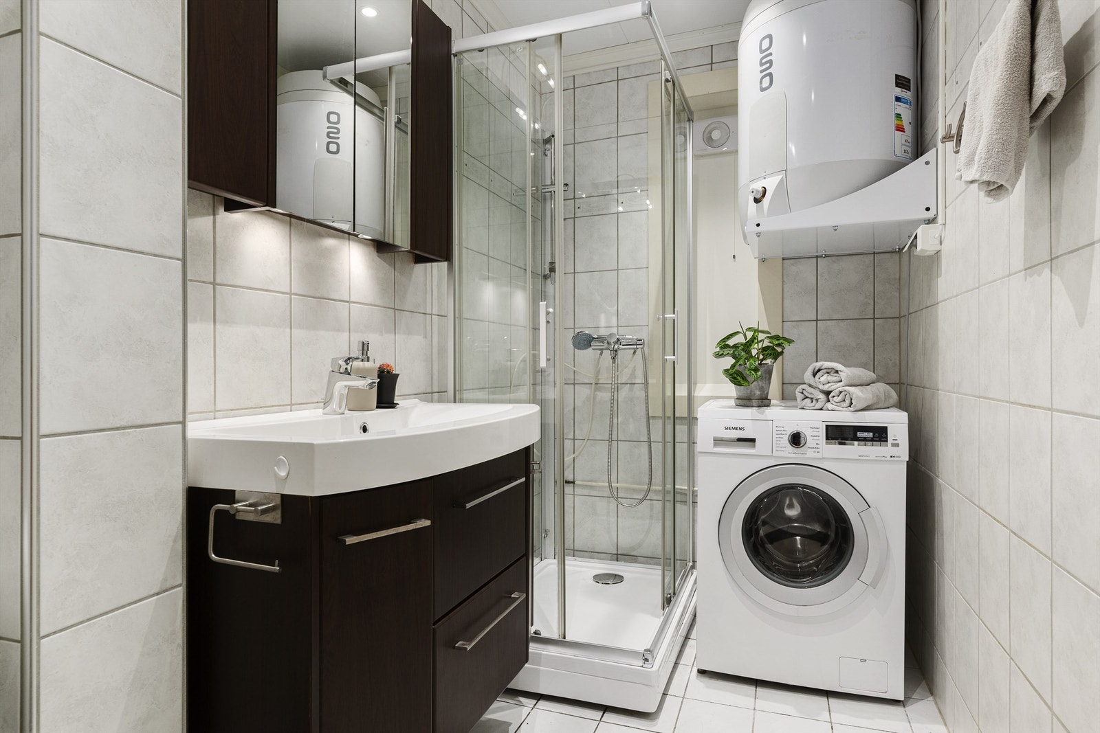 Baderom med flislagt gulv med gulvvarme, flislagte vegger og takplater i himling, med innfelte downlights. Takplater og downlights er nylig byttet Galleribilde