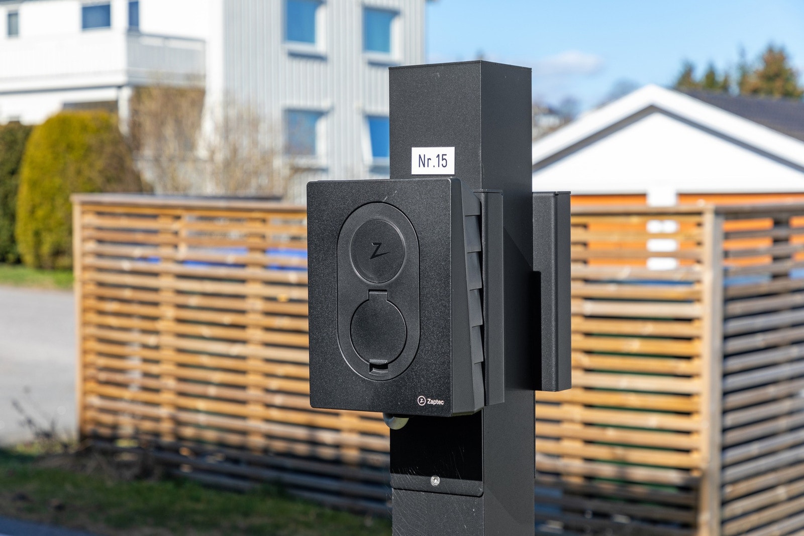Det er parkering på en reservert biloppstillingsplass med elbillader. Galleribilde