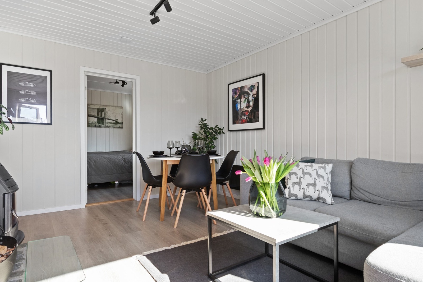 Rommet har lysmalte vegger mot lyst laminatgulv, og dagslyset strømmer inn via store vinduer på endeveggen Galleribilde