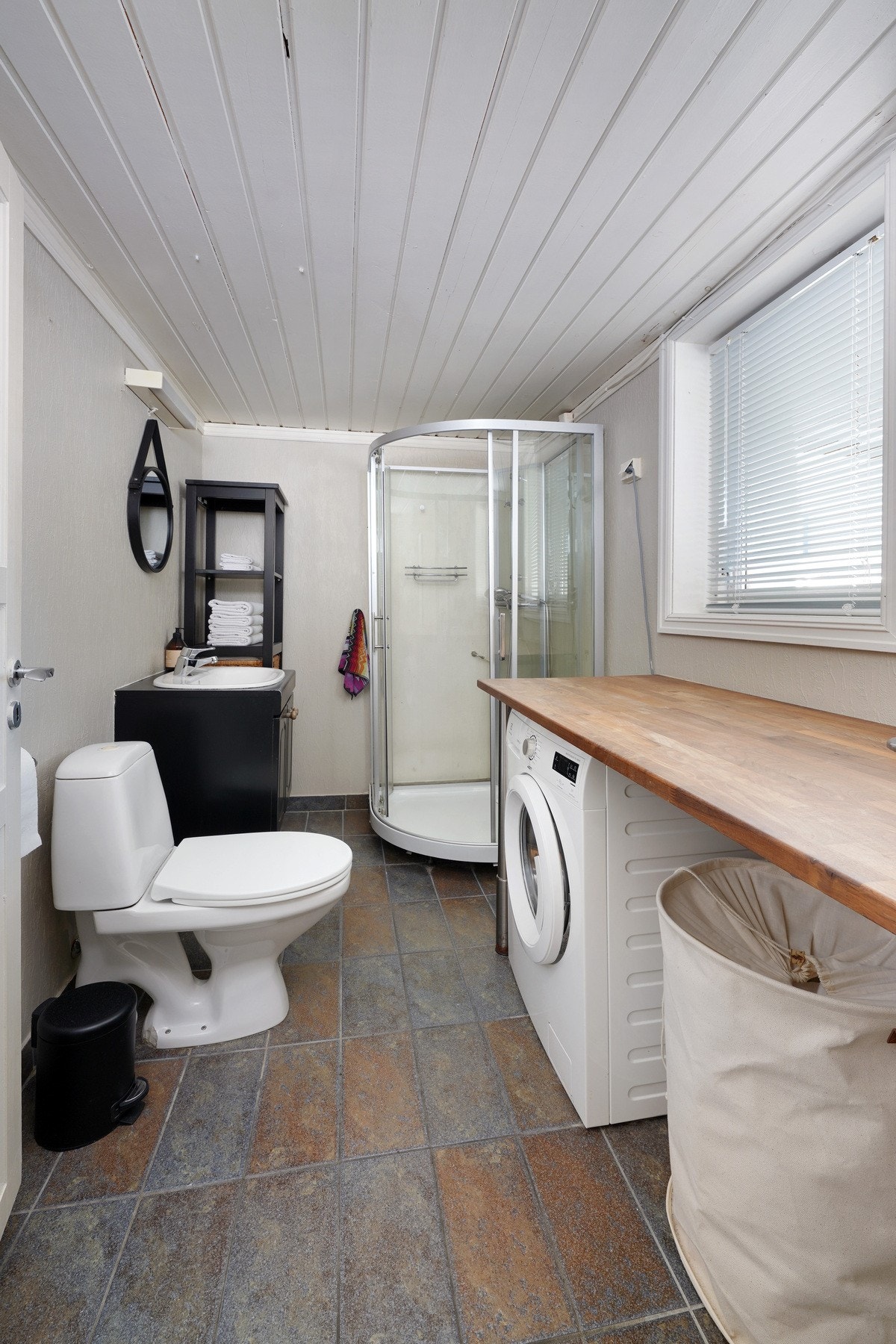 Bad med opplegg for vaskemaskin, tørketrommel og med varmekabler i gulv. Galleribilde