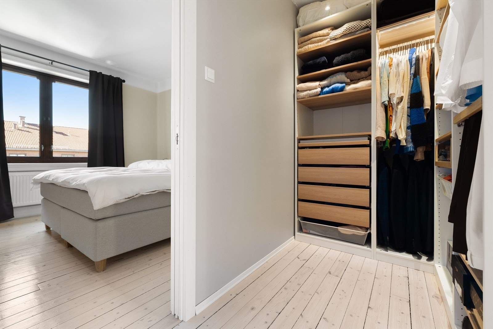 Inngang fra hovedsoverommet til walk-in closet med garderobeløsninger. Galleribilde