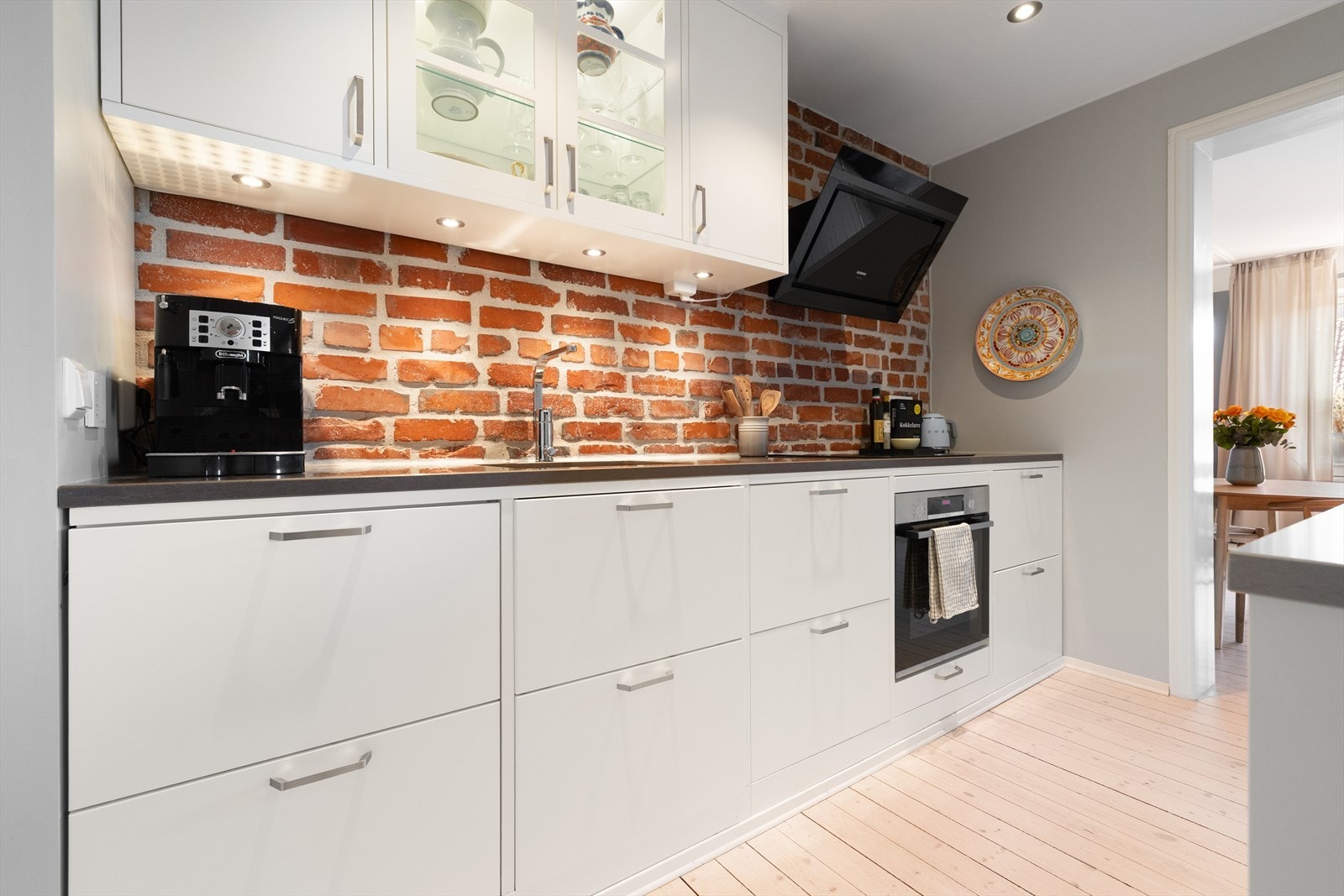 Velutstyrt kjøkken med rene linjer og moderne hvite fronter. Integrerte hvitevarer, rikelig med lagringsplass i skap og kjøkkenøy (kan flyttes). Galleribilde