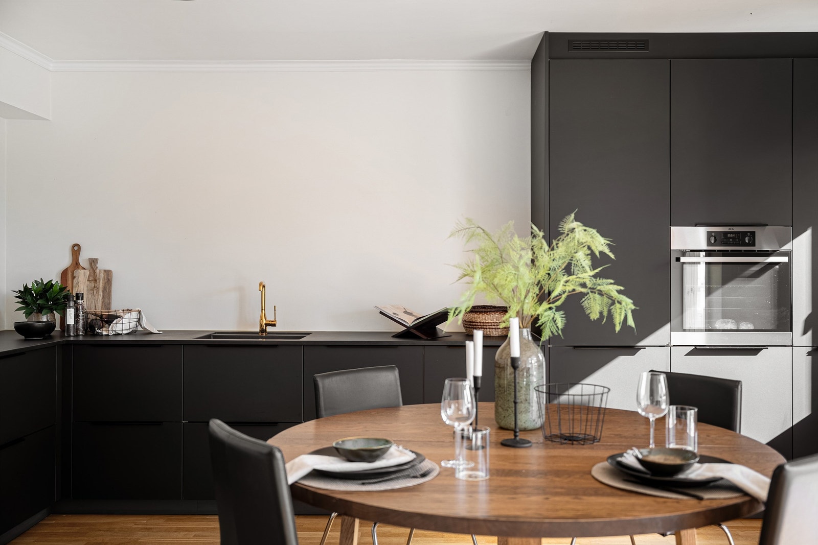 Innredning i matt svar, benkeplate i svart og rikelig med skap og arbeidsflater på benk. Galleribilde