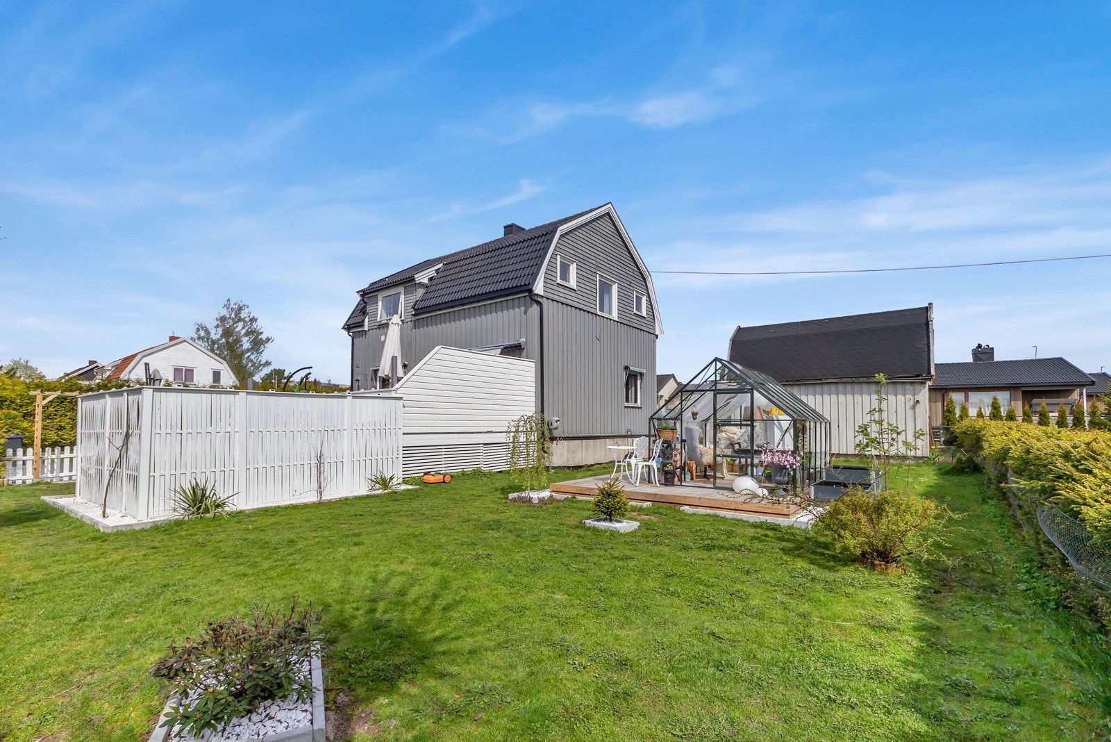 Tomten på 997 kvm er flat, solrik og pent opparbeidet med gressplen, prydbusker og gruslagt gårdsplass. Galleribilde
