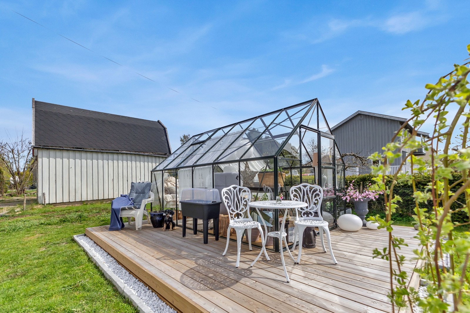 Uteplassen rundt er stilfullt opparbeidet med hvit stein og frodig beplantning. Galleribilde