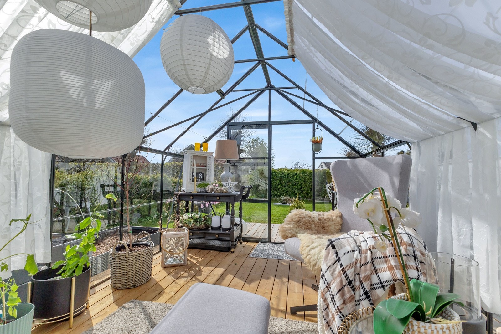 Drivhuset kan innredes med godstoler og myke tekstiler for å skape et lunt uterom. Galleribilde