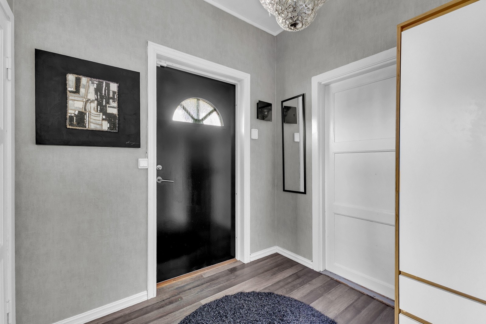 Vel inne blir vi ønsket velkommen i en pen entré med grå tapet på veggene og matchende laminat på gulvet. Galleribilde
