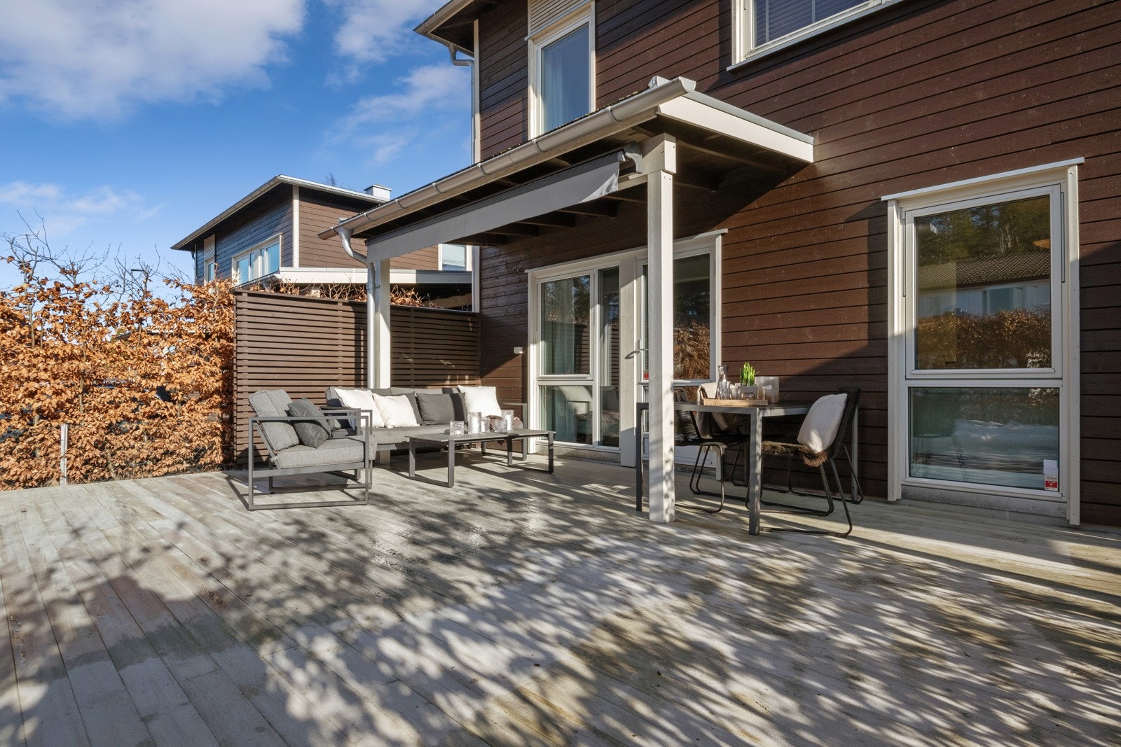 Terrassen har noe overbygg med markise, levegg på siden og dekke av terrassebord. Det er god plass til ulike utemøbler, og den vestvendte orienteringen gir gode solforhold. Galleribilde