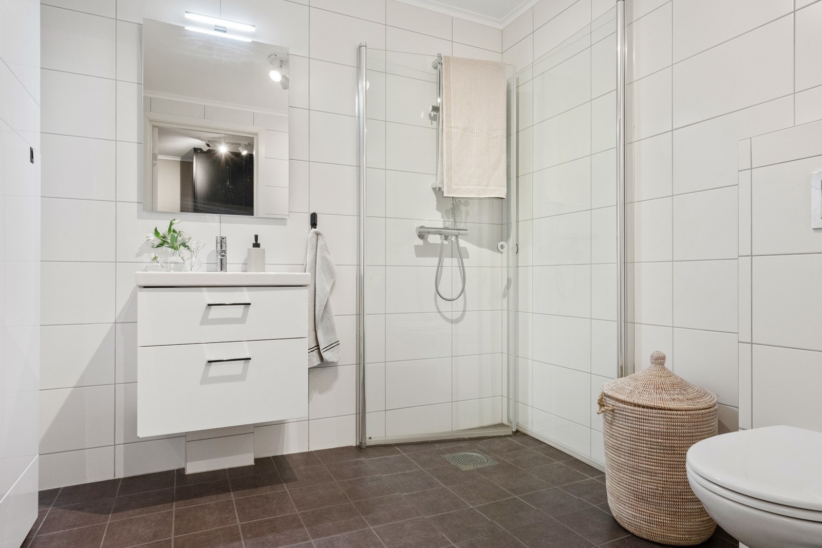 Badet i første etasje har inngang fra entreen og er pent utført med mørke fliser på gulvet, lyse fliser på veggene, gulvvarme og spotlampe i taket. Galleribilde