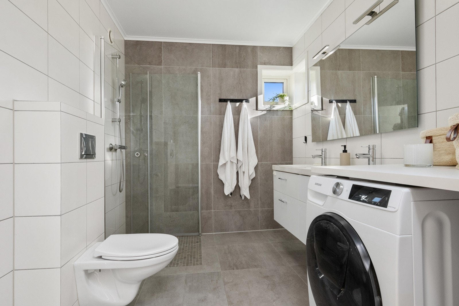 Badet i andre etasje er familievennlig innredet med dobbelservant på hvit skuffeseksjon. Galleribilde