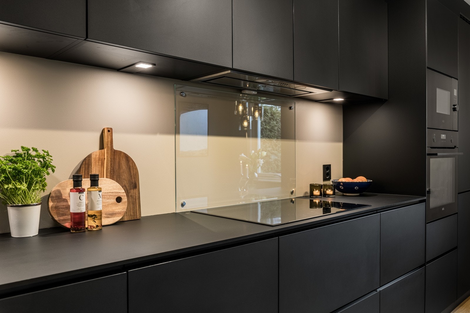 Veggen bak koketoppen og kummen beskyttes med glassplater, og under overskapene er det montert god arbeidsbelysning. Galleribilde