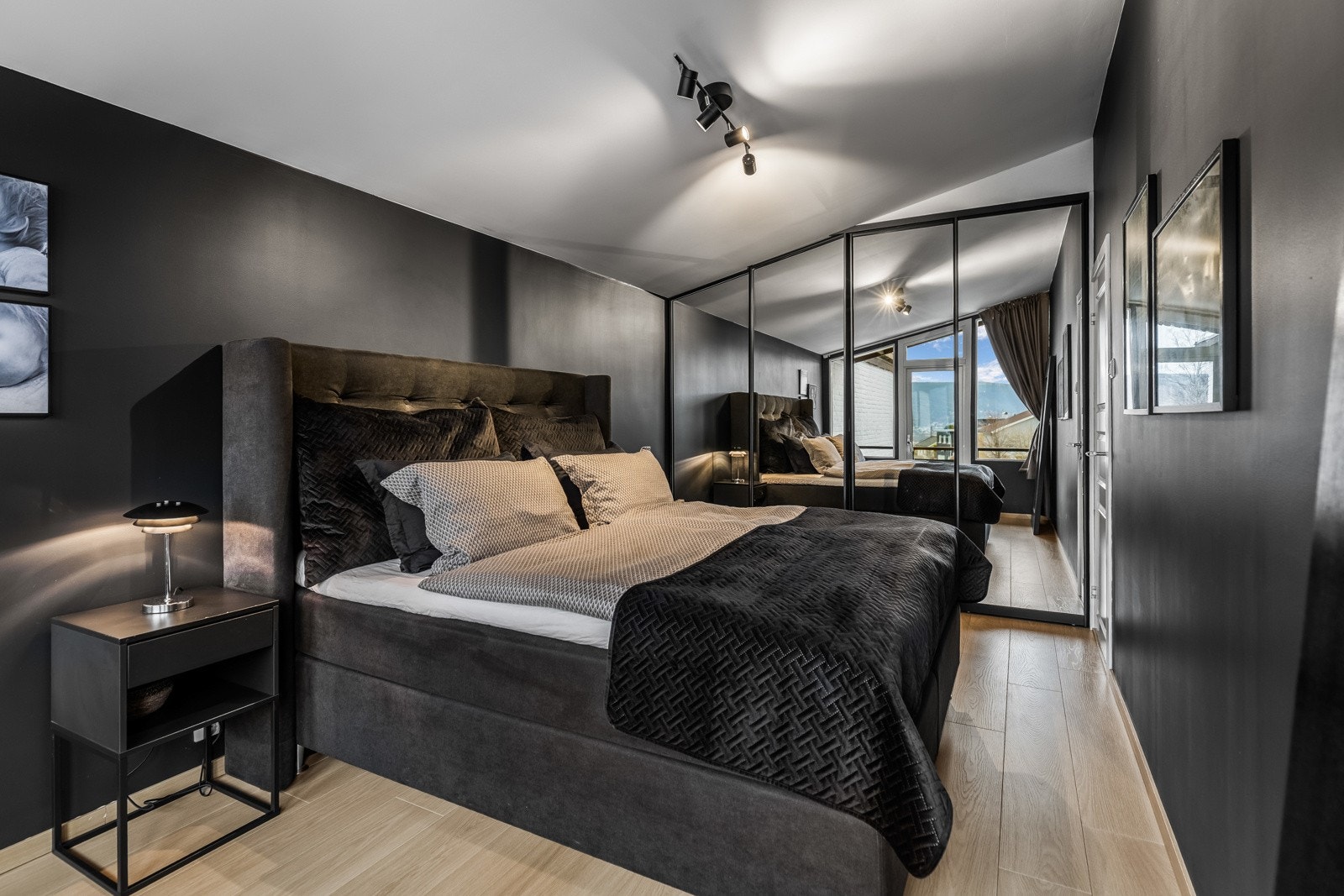 Hovedsoverommet har en plassbygget garderobeløsning med speilskyvedører, elegant innrammet med sorte rammer for et gjennomført preg. Galleribilde