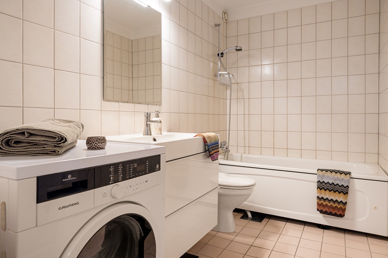 Stilrent og flislagt baderom med elektriske varmekabler i gulv. Galleribilde