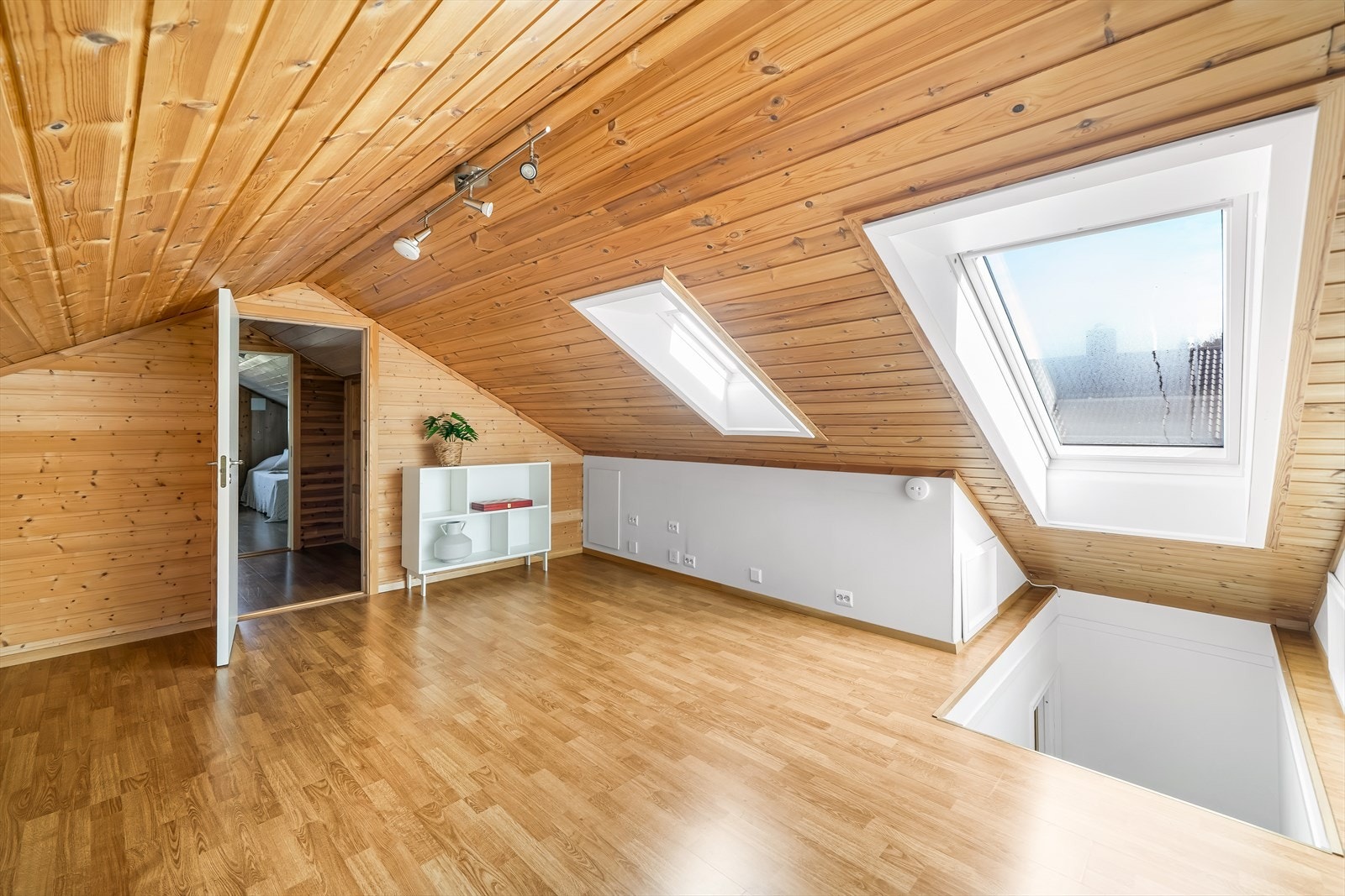 Mye naturlig lys fra stort takvindu i gang på loft. Galleribilde