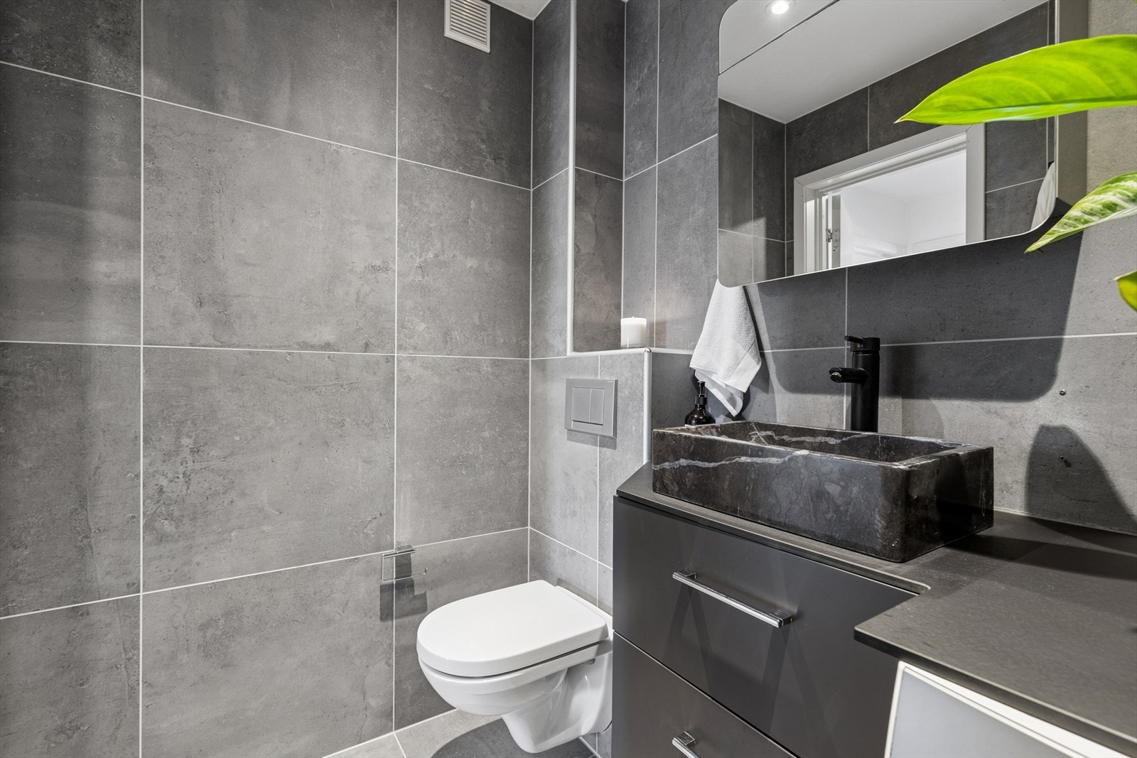 Baderommet har flislagte veggflater og malte plater med integrert belysning i himlingen. Galleribilde