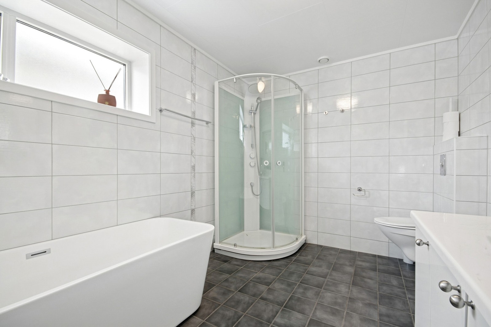 Badet oppleves som romslig og har plass til dusjkabinett og badekar Galleribilde