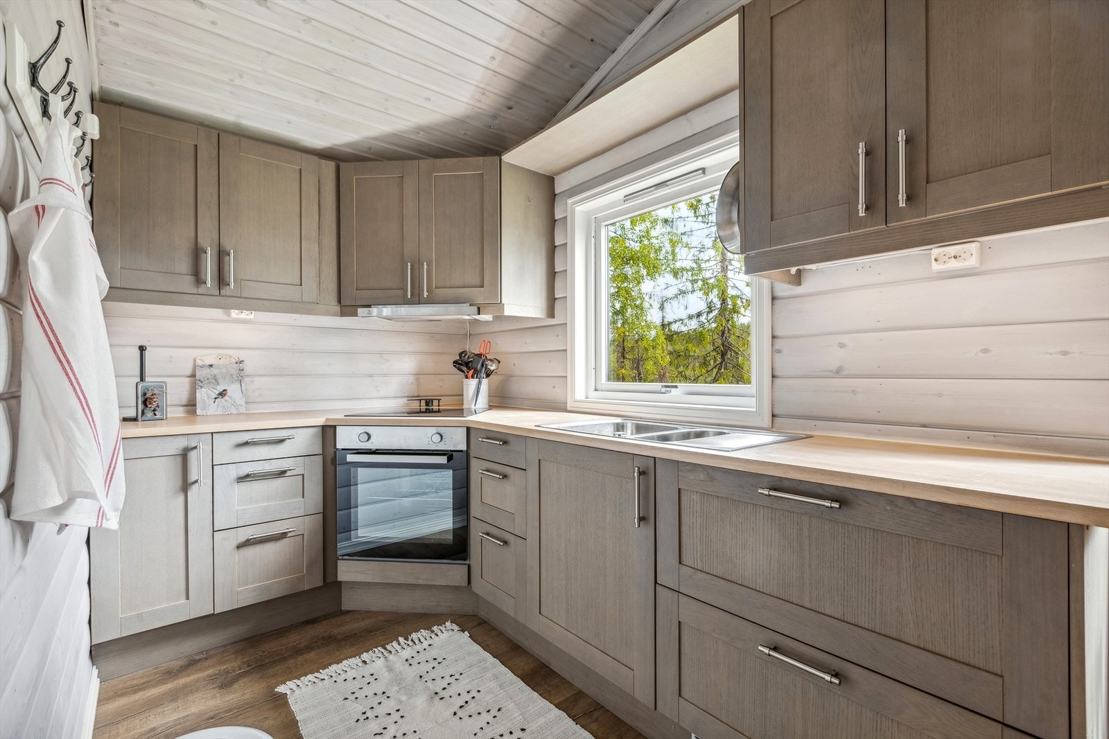 Kjøkkenet er utstyrt med integrerte hvitevarer som består av koketopp, stekeovn og kjøleskuffer Galleribilde