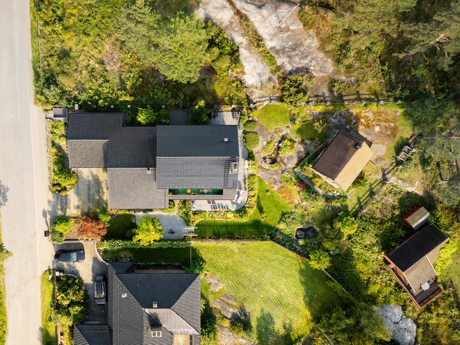 Parkmessig opparbeidet, hvor flere soner på tomten har bl.a. gressplener, sitteplasser, frukttrær og et anneks som i dag brukes til verksted og atelier. Galleribilde