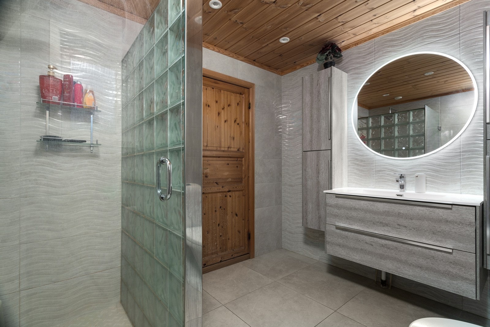 Rommet er utstyrt med innredning med heldekkende servant, speil med integrert belysning, toalett og dusjhjørne med glassdør. Galleribilde