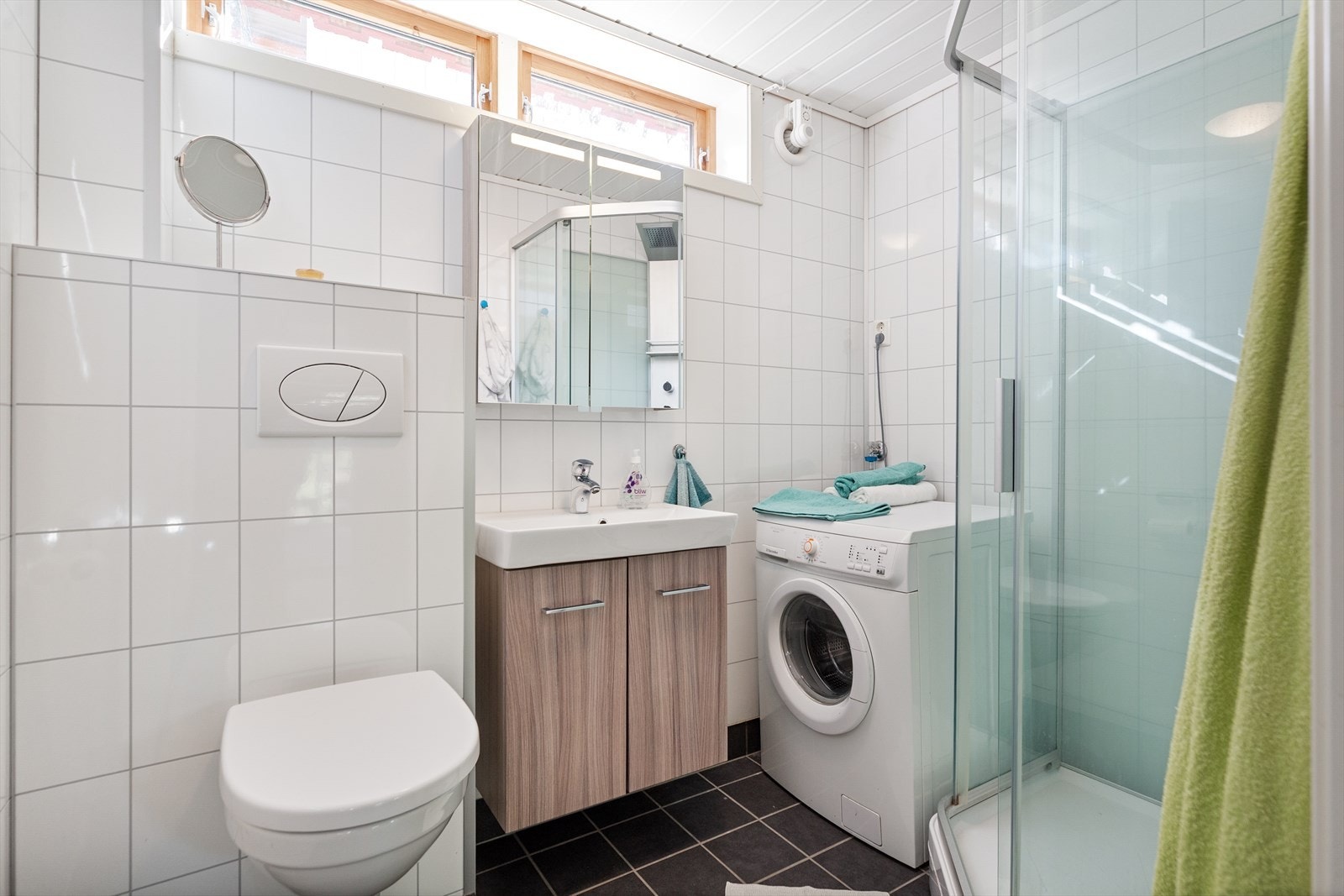 Badet er på 3,8 m² med praktisk baderomsinnredning, gulvvarme, dusjkabinett og ferdig opplegg for vaskemaskin. Galleribilde