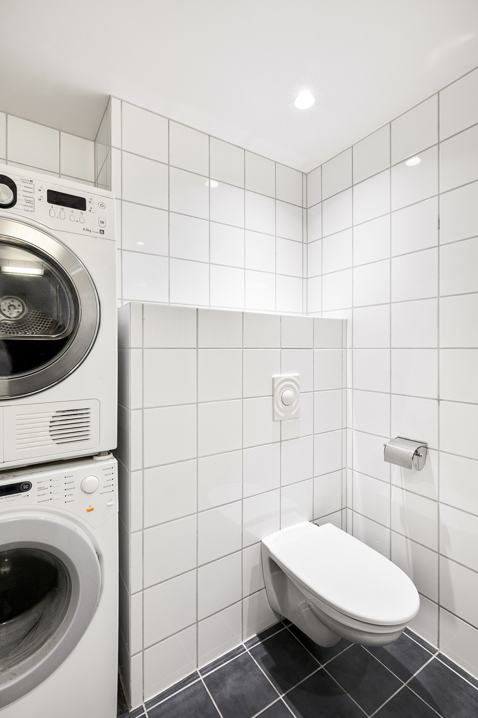 Det er innredet med seksjon med nedfelt servant, vegghengt toalett med skjult sisterne, dusjhjørne med glassdører og opplegg for vaskemaskin. Galleribilde