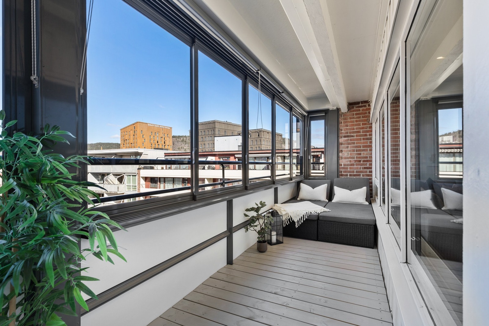 Balkongen har gulvoverflate med terrassebord, og rekkverk av metall, plateemner og skyvbare glassfelter Galleribilde