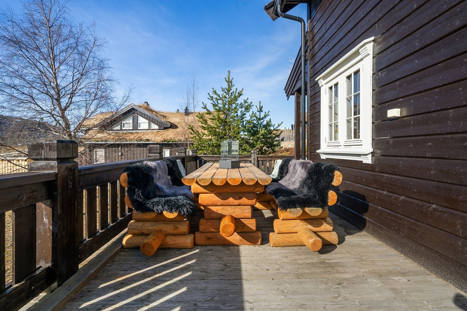 Flere sittegrupper på terrassen rundt hytten. Galleribilde