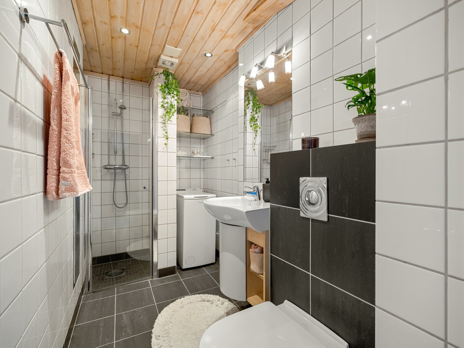 Fint, flislagt bad med gulvvarme. Badet består av baderomsinnredning med benkeskap med glatt front, servant og innfliset speil på veggen. Galleribilde