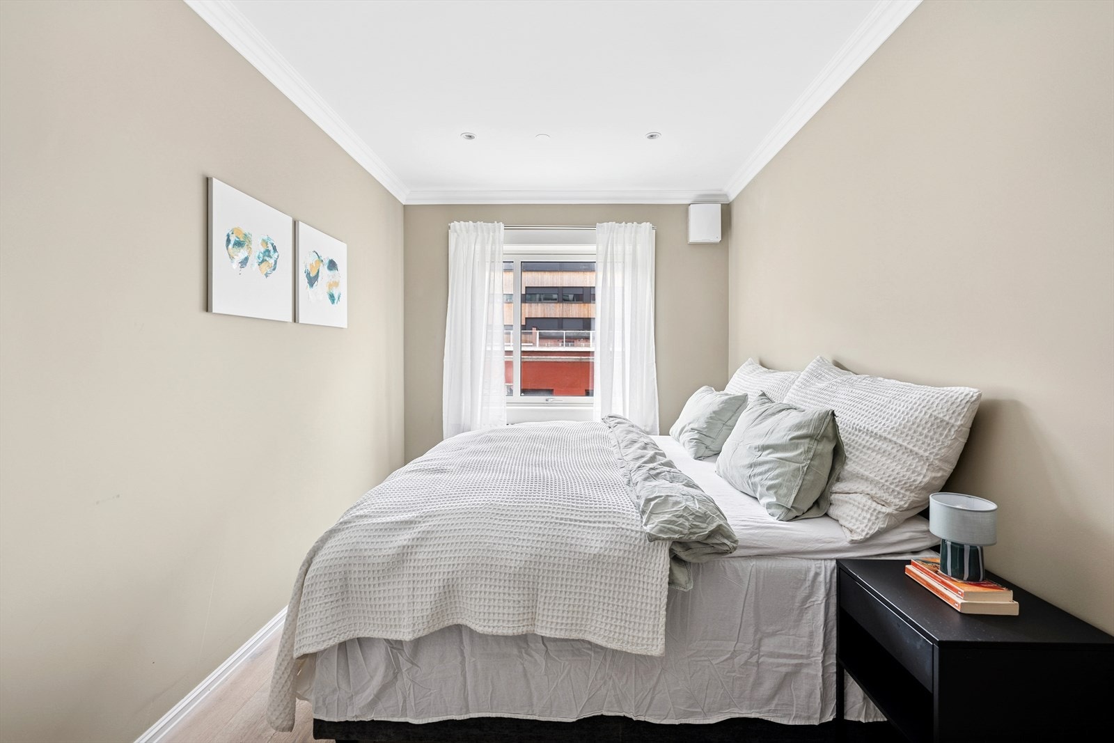 Romslig soverom med god plass til dobbeltseng, nattbord og tilhørende møblement Galleribilde