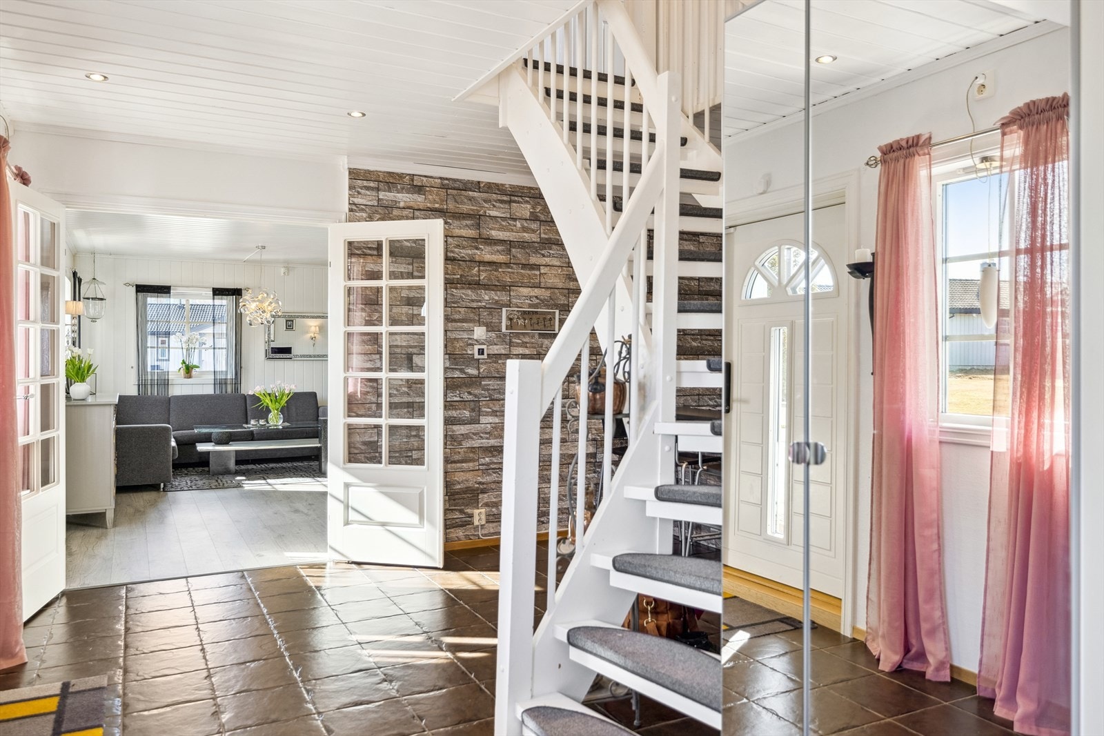 Man ønskes velkommen av en entré med speilskap, downlights og flislagt gulv. Galleribilde