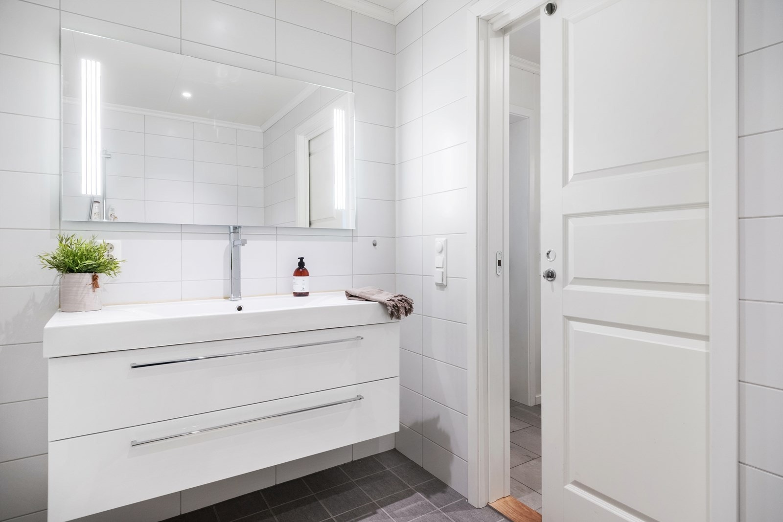 Badet i hovudetasjen er innreia med vegghengd toalett, servant med underskuff og dusjhjørne. Galleribilde