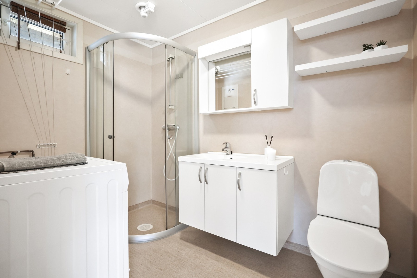Badet har gulvbelegg med gulvvarme og veggbelegg på vegg. Det er dusjnisje med glassvegg og glassdør. Galleribilde