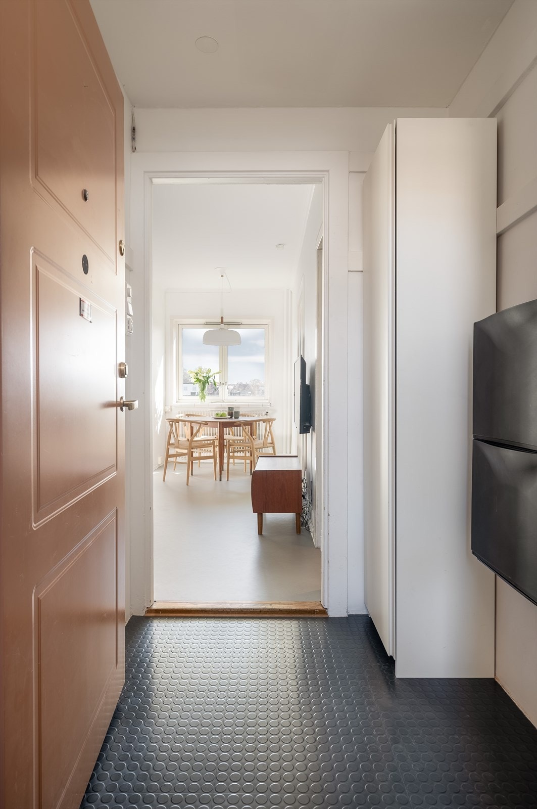 Lys entré med plass til yttertøy og sko i garderobeskap. Galleribilde