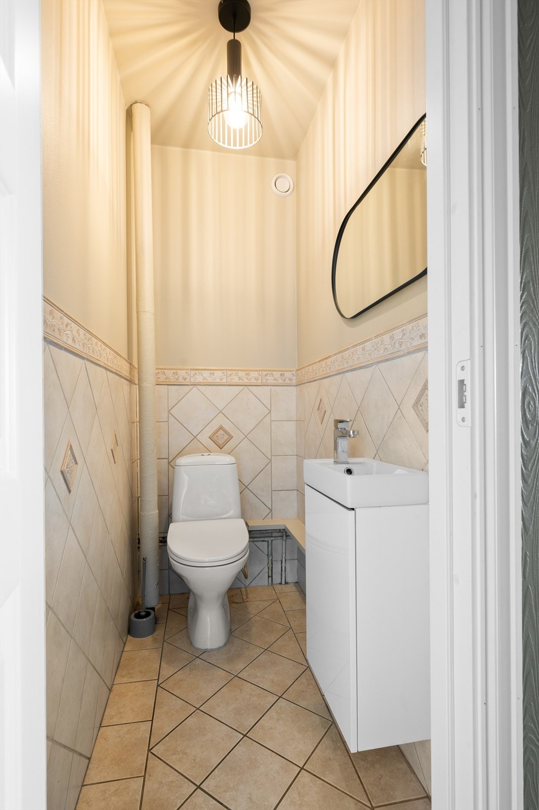 Like ved siden av badet har leiligheten et praktisk separat toalettrom innredet med gulvstående toalett og servant i innredning. Galleribilde