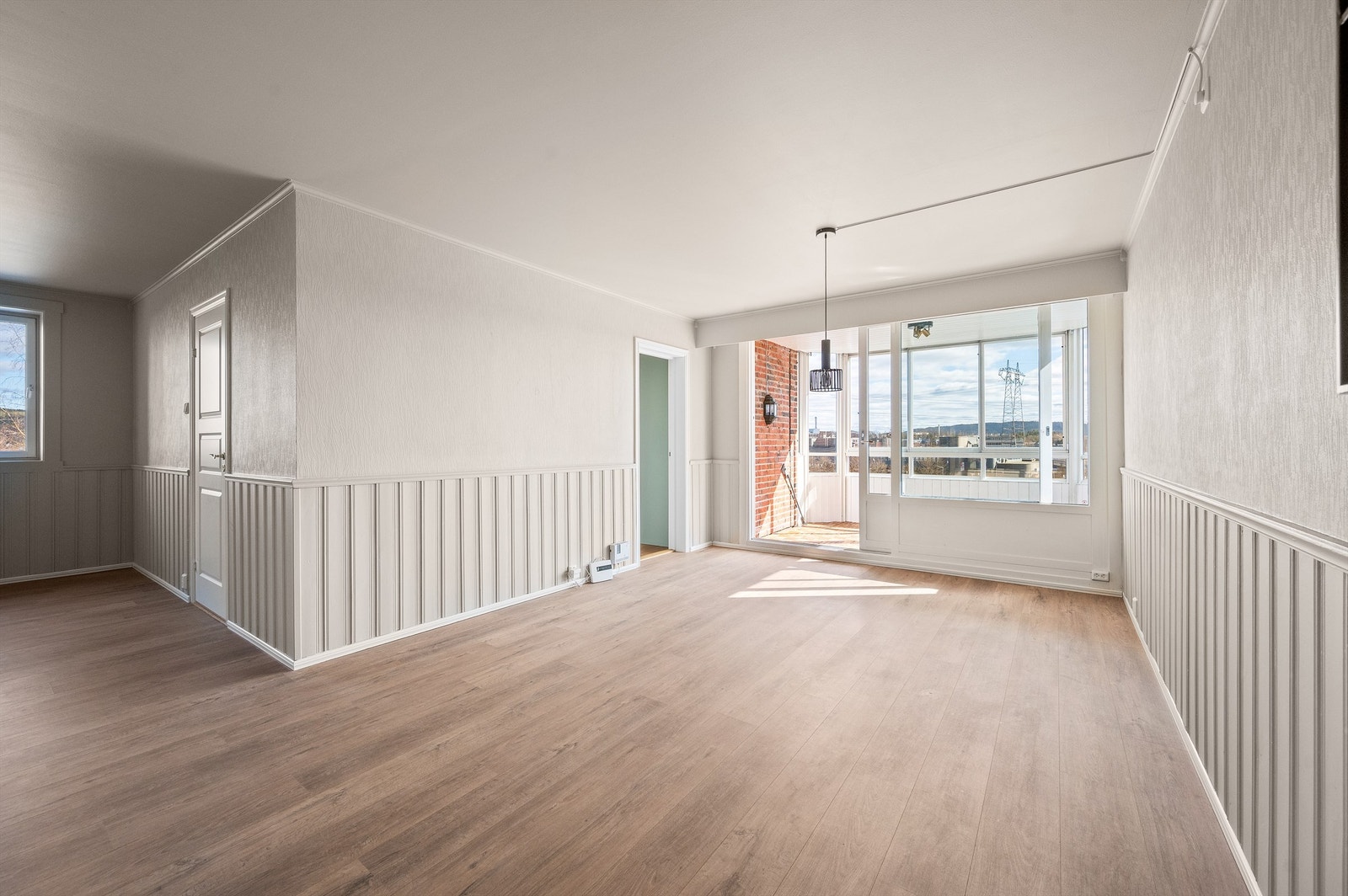 Store vindusflater slipper inn rikelig med lys og skaper en lys og luftig atmosfære i stuen. Galleribilde