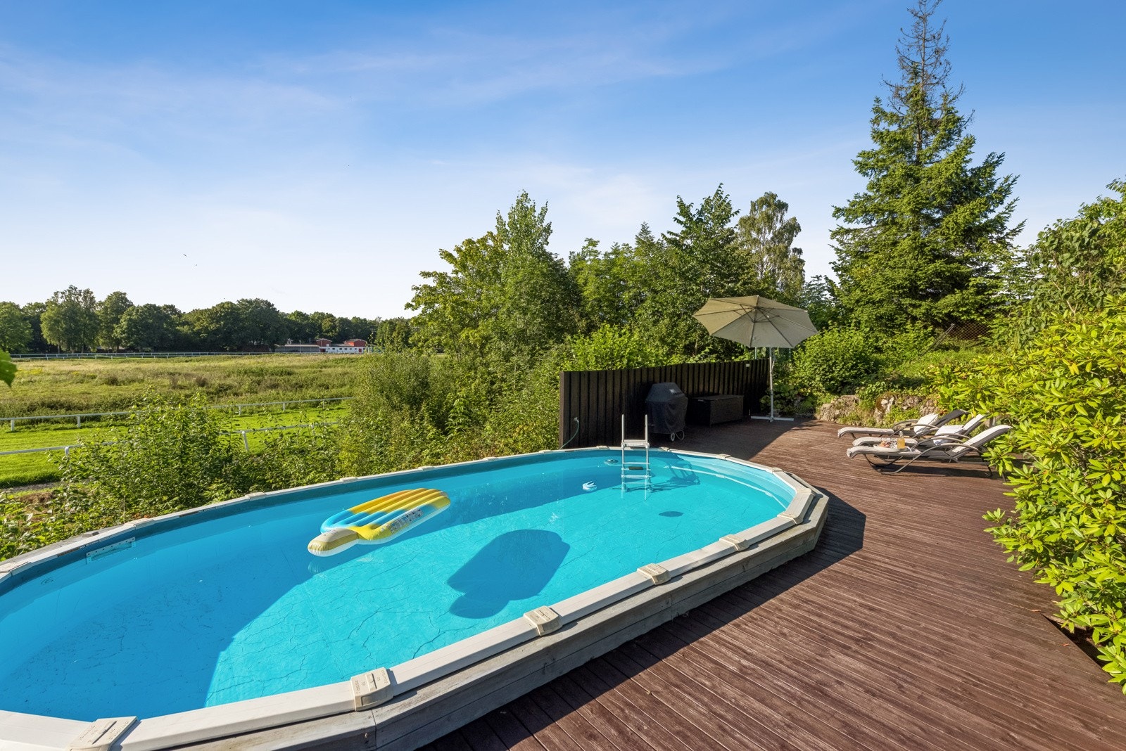 Bassengområde er skjermet med levegg og beplanting. Galleribilde