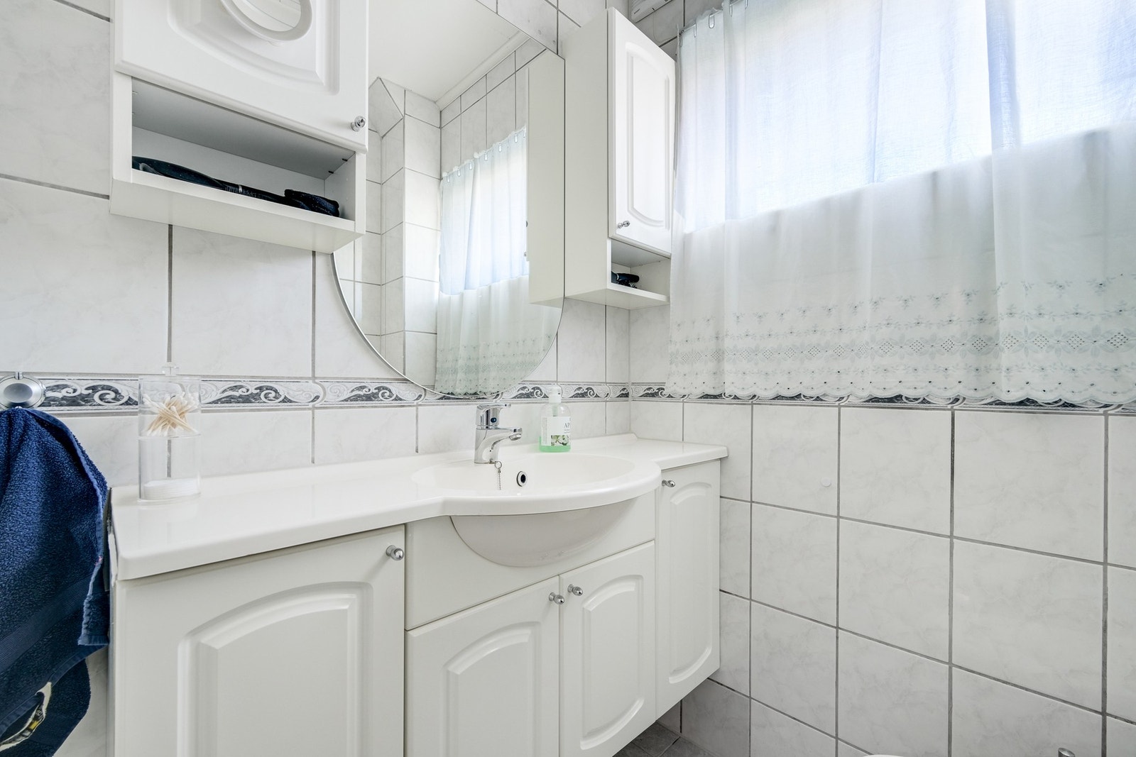 Badet inneholder servant med skaper, speil, wc og dusjhjørne. Galleribilde