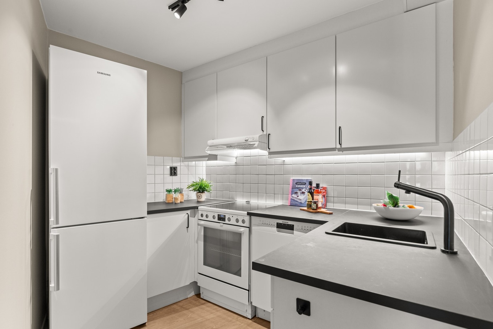 Kjøkkeninnredning med glatte fronter og laminat benkeplater. Galleribilde