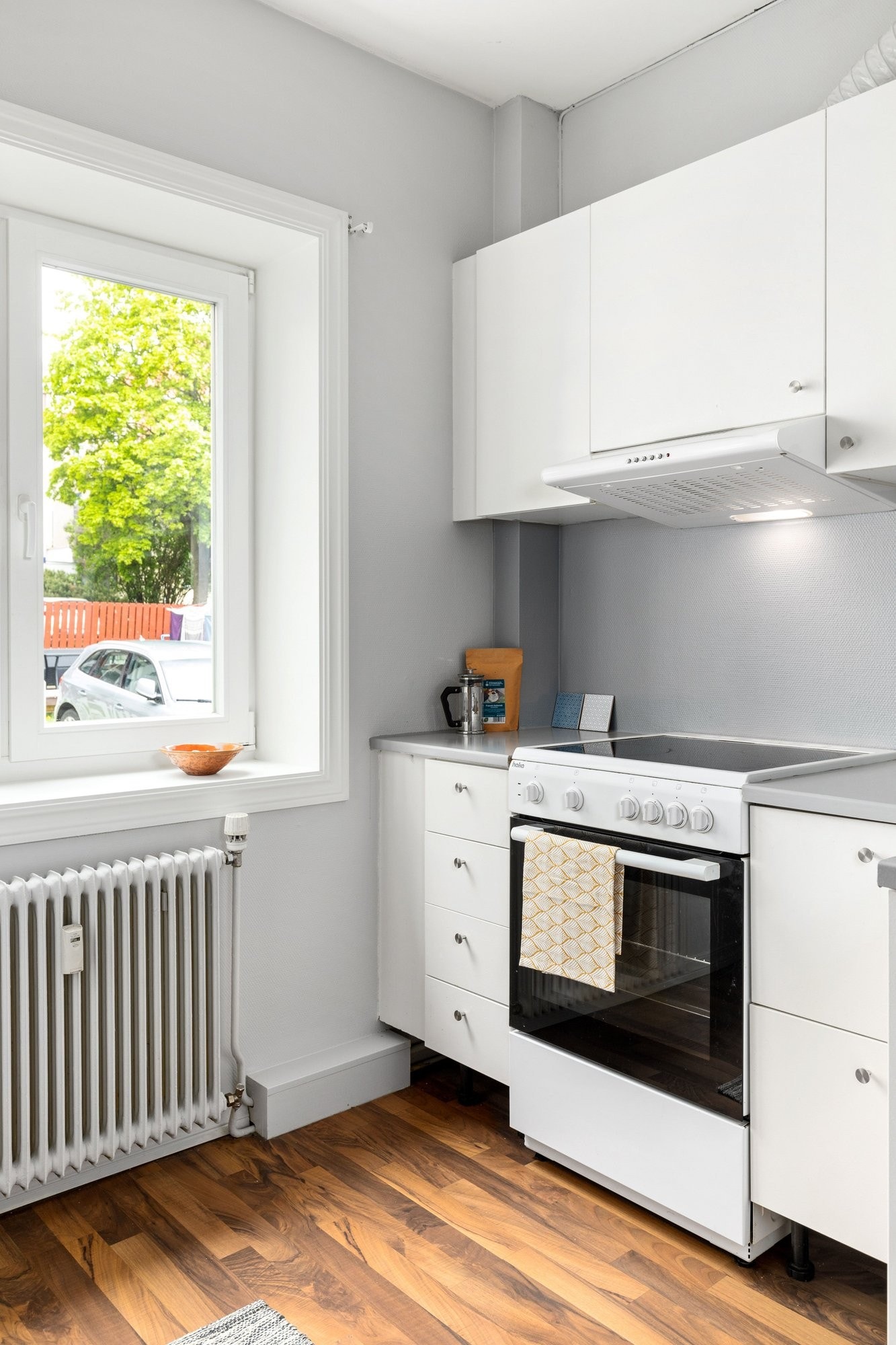 Kjøkken med vindu som vender mot rolig grønn bakgård. Galleribilde