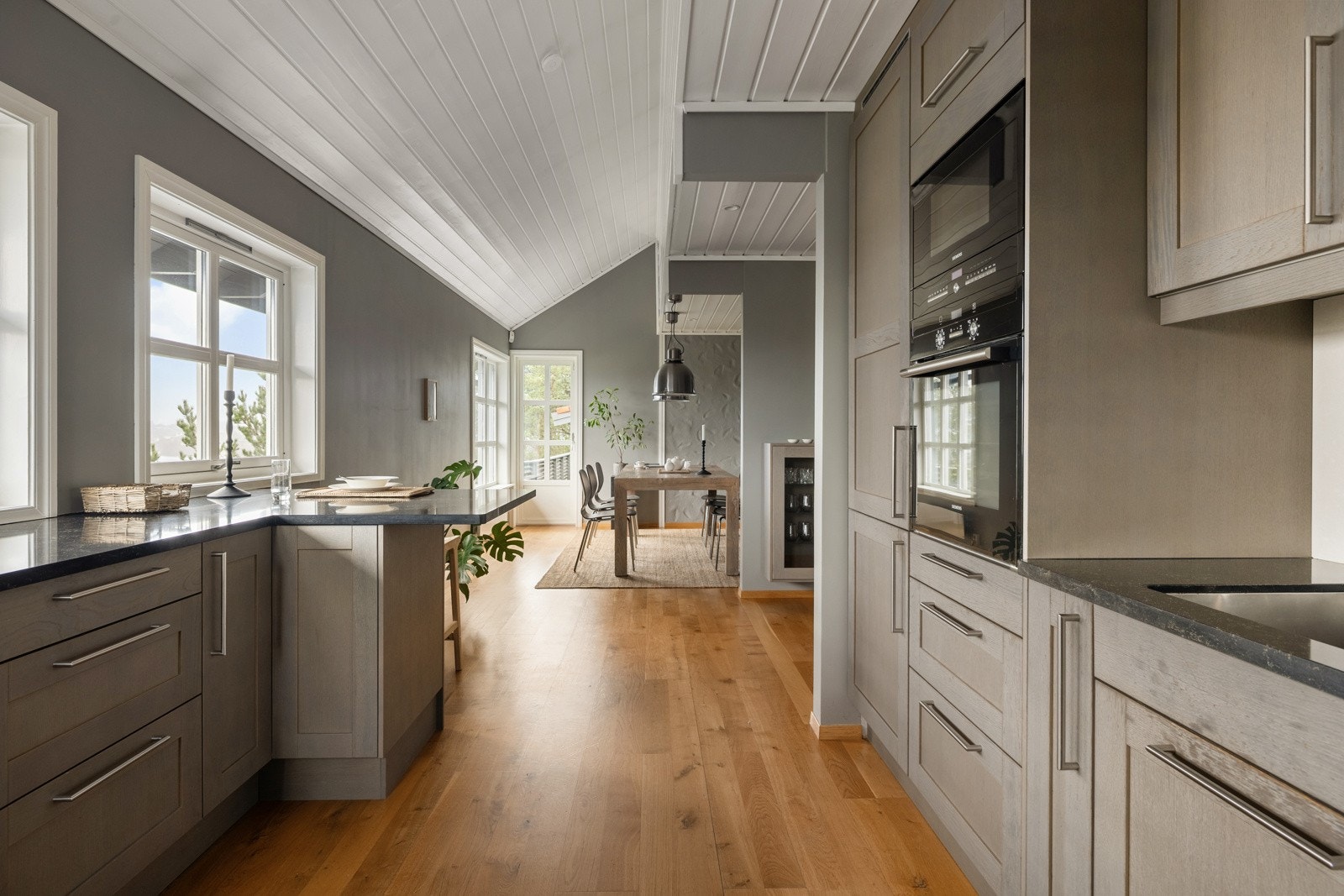 Spisestuen og kjøkkenet har en praktisk åpen løsning som gjør dette til et sosialt rom perfekt for middagsbesøk. Galleribilde