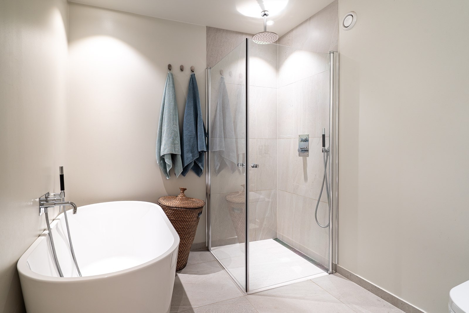 Et flott design badekar og en hjørnedusj med innfellbare glassdører. Downlights med dimmer skaper en stemningsfull atmosfære. Det er sentralt avtrekk. Galleribilde