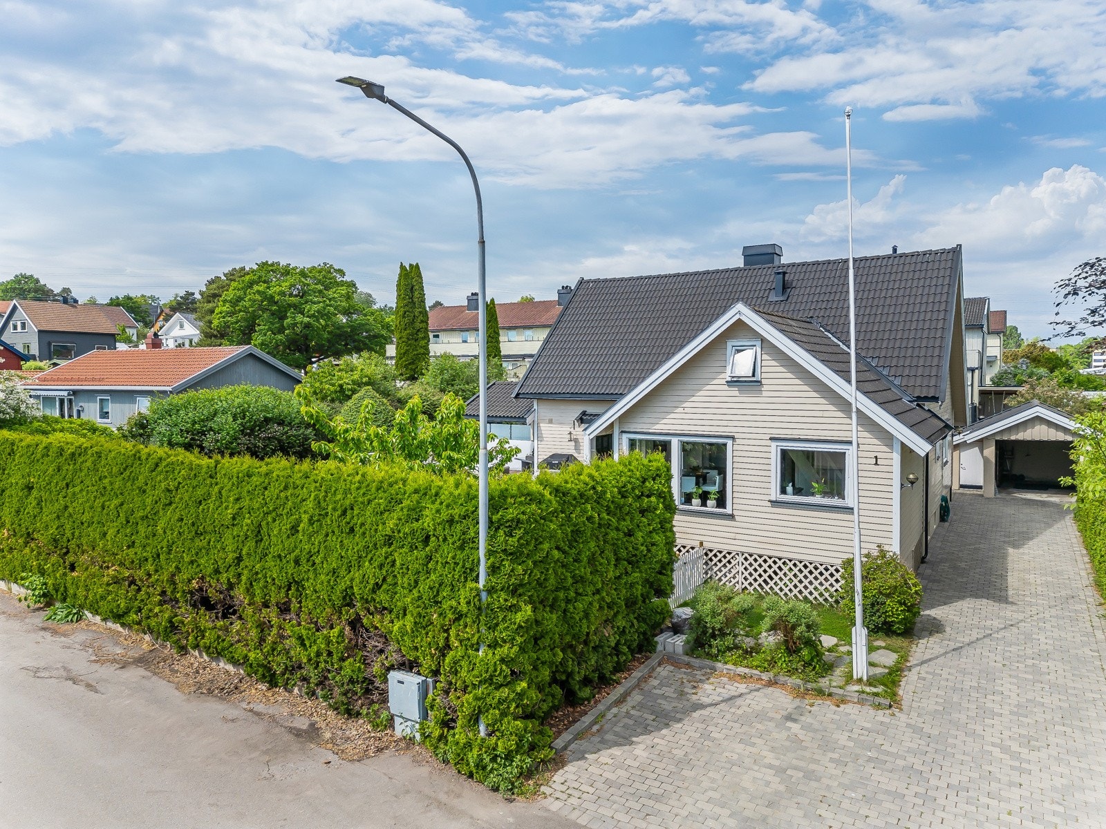 Her ser vi fasaden mot syd med den steinsatte gårdsplassen og garasjen Galleribilde