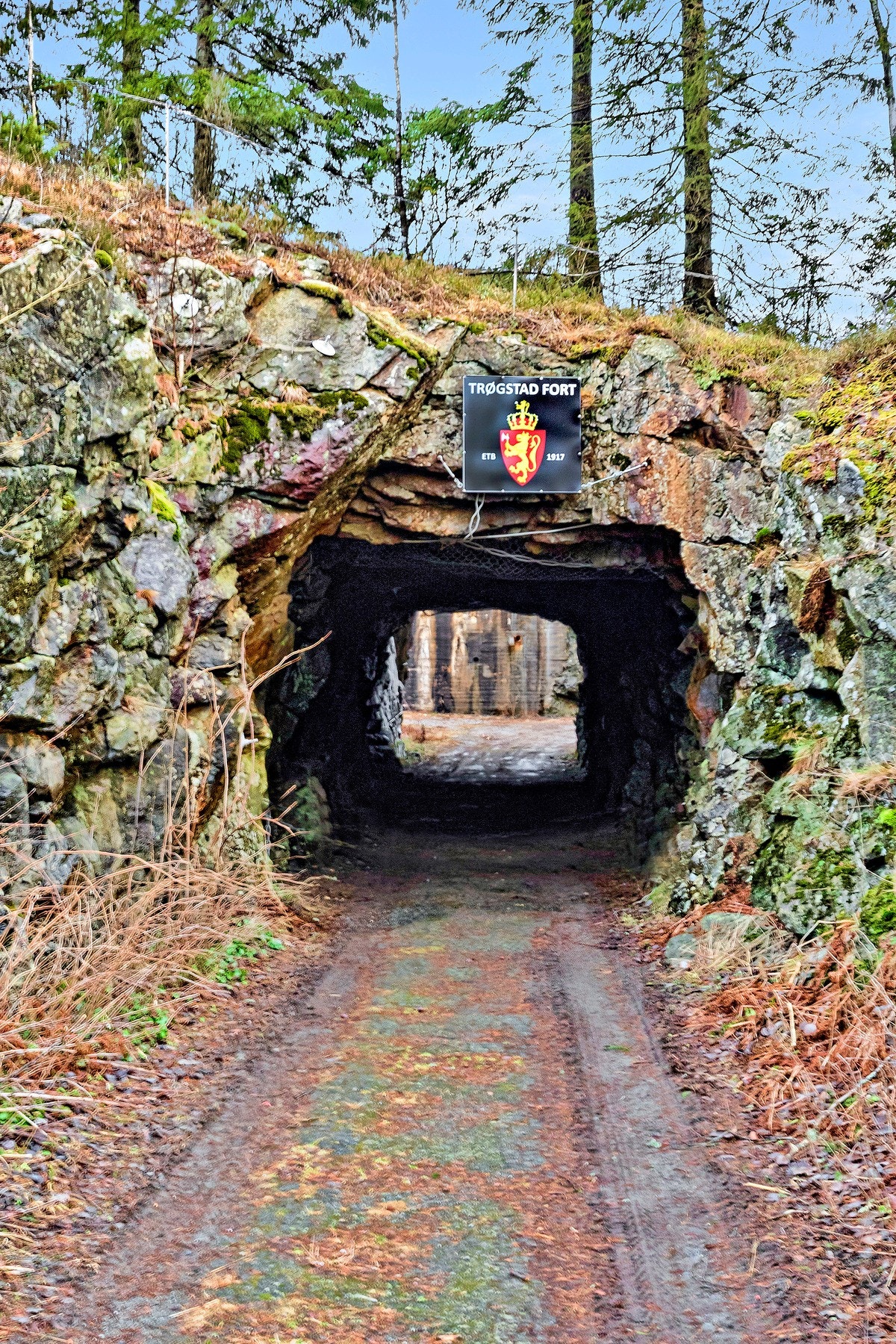 Inngang til Trøgstad fort, etablert i 1917, med skilt over tunnelåpning. Galleribilde