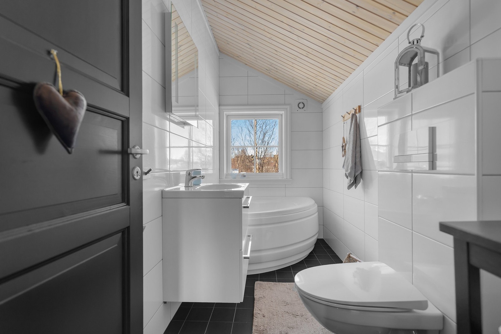 Det er badekar, vegghengt wc og badromsinnredning med poselenstopp på badet oppe. Galleribilde