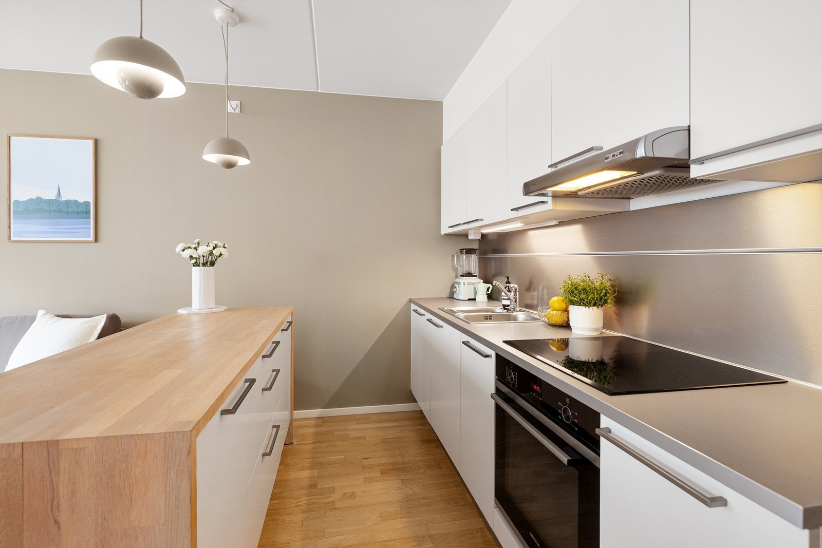 Kjøkkenet er utstyrt med hvitevarer som komfyr og platetopp fra Siemens (2021), oppvaskmaskin, kjøl/ fryseskap samt ventilator over kokesone. Galleribilde